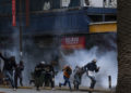 Protesters run fron tear gas at a planned demonstration called after a nationwide deadly protest against a controversial now-withdrawn tax bill left over 20 dead in downtown Nairobi, on June 27, 2024. Kenyans are preparing to take to the streets on Thursday for a white march the day after President William Ruto announced the withdrawal of the draft budget providing for tax increases, at the origin of a protest which foundered in murderous violence. (Photo by Kabir Dhanji / AFP)