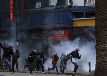 Protesters run fron tear gas at a planned demonstration called after a nationwide deadly protest against a controversial now-withdrawn tax bill left over 20 dead in downtown Nairobi, on June 27, 2024. Kenyans are preparing to take to the streets on Thursday for a white march the day after President William Ruto announced the withdrawal of the draft budget providing for tax increases, at the origin of a protest which foundered in murderous violence. (Photo by Kabir Dhanji / AFP)