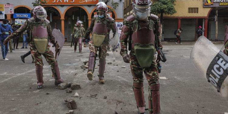 Kenyan anti-riot police clear a barricade from the street after repelling protestors along Moi avenue during demonstrations called after a nationwide deadly protest against a controversial now-withdrawn tax bill left over 20 dead in downtown Nairobi, on June 27, 2024. Kenyans are preparing to take to the streets on Thursday for a white march the day after President William Ruto announced the withdrawal of the draft budget providing for tax increases, at the origin of a protest which foundered in murderous violence. (Photo by Tony KARUMBA / AFP)