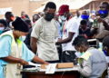 Ugandan presidential candidate and singer Robert Kyagulanyi Ssentamu, known as Bobi Wine, is processed by electoral officials before casting his ballot in the presidential elections in Kampala, Uganda, January 14, 2021. REUTERS/Abubaker Lubowa