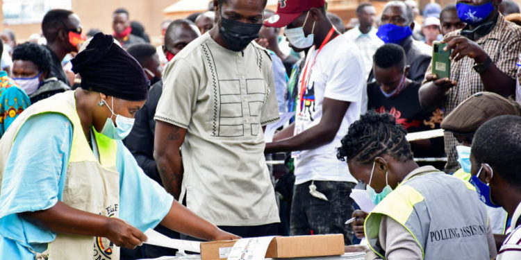 Ugandan presidential candidate and singer Robert Kyagulanyi Ssentamu, known as Bobi Wine, is processed by electoral officials before casting his ballot in the presidential elections in Kampala, Uganda, January 14, 2021. REUTERS/Abubaker Lubowa