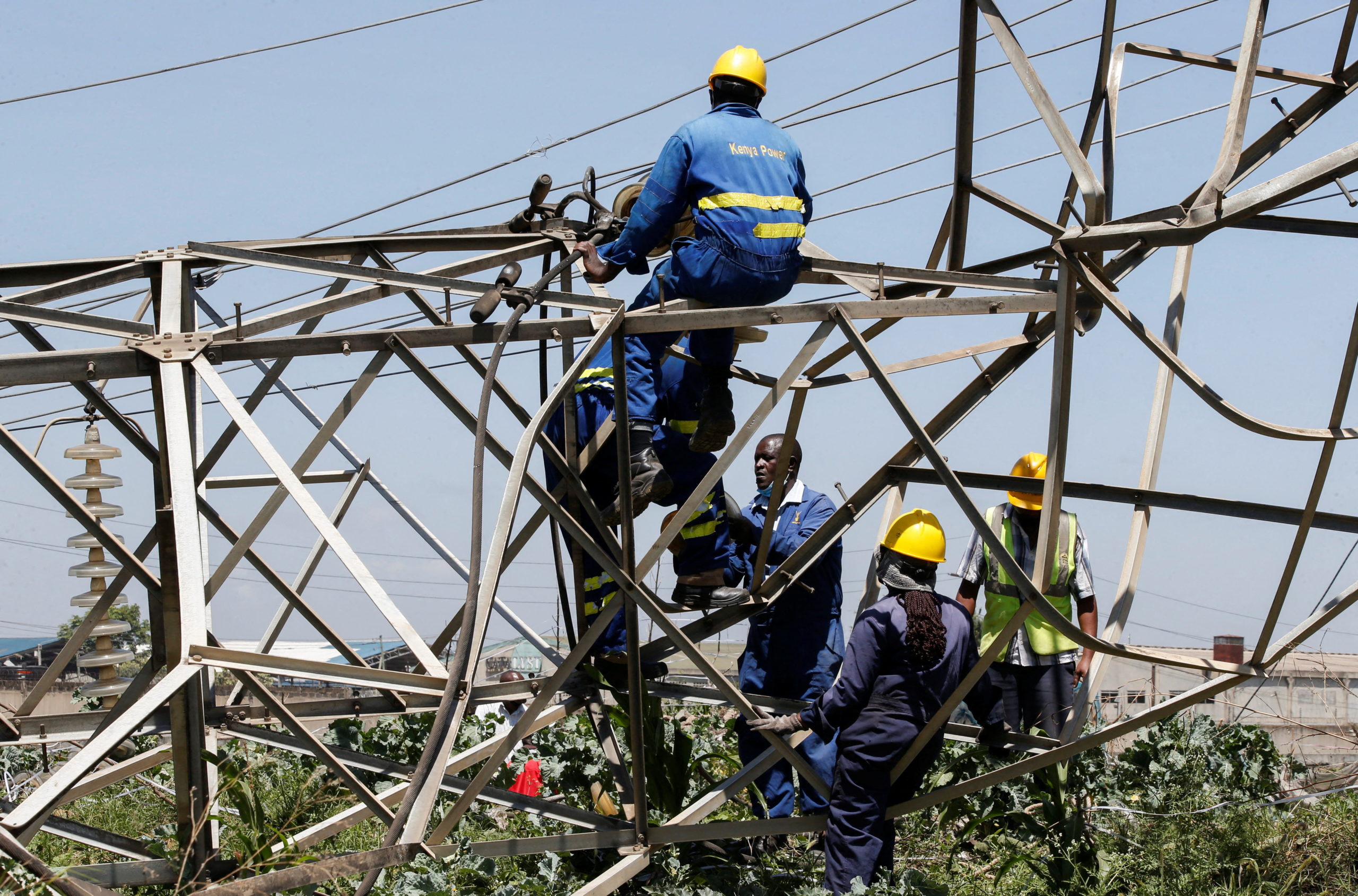 Technicians work on collapsed high voltage electricity transmission pylons from the Kiambere hydroelectric dam in Embakasi district of Nairobi, Kenya January 12, 2022. REUTERS/Monicah Mwangi