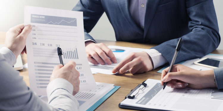 Financial service professional team at work, hands close with business reports and paperwork