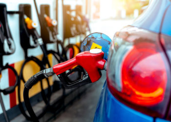 Car fueling at gas station. Refuel fill up with petrol gasoline. Petrol pump filling fuel nozzle in fuel tank of car at gas station. Petrol industry and service. Petrol price and oil crisis concept.