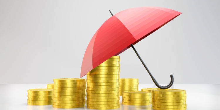 Gold coins and umbrella stacked on top of each other. insurance concept. Horizontal composition with copy space.