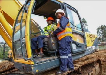 East Africa Breweries Limited Group Managing Director & CEO, Jane Karuku tries out the excavator by the operator Lydia Wahu during a ground breaking ceremony of a micro brewery set to be put up at the Ruaraka Headquarters.