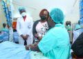 M-PESA Foundation Executive Director, Karen Basiye, interacts with 53- year- old, Ruth Njoki, (a fistula patient at Kenyatta National Hospital). Also present is KNH Physiotherapist, Rebecca Ng’ong’a.