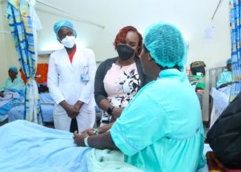 M-PESA Foundation Executive Director, Karen Basiye, interacts with 53- year- old, Ruth Njoki, (a fistula patient at Kenyatta National Hospital). Also present is KNH Physiotherapist, Rebecca Ng’ong’a.