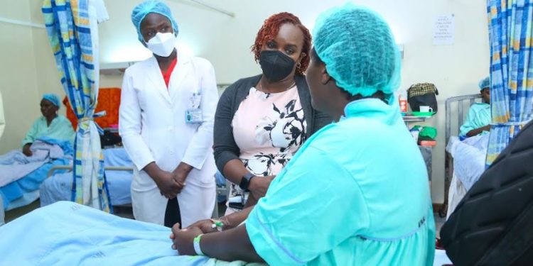 M-PESA Foundation Executive Director, Karen Basiye, interacts with 53- year- old, Ruth Njoki, (a fistula patient at Kenyatta National Hospital). Also present is KNH Physiotherapist, Rebecca Ng’ong’a.