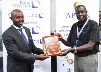 Kenya Orient Life Assurance General Manager Jackson Muli (L) receives the 'Pension Marketing Campaign of the Year' award from APTAK President Hosea Kili