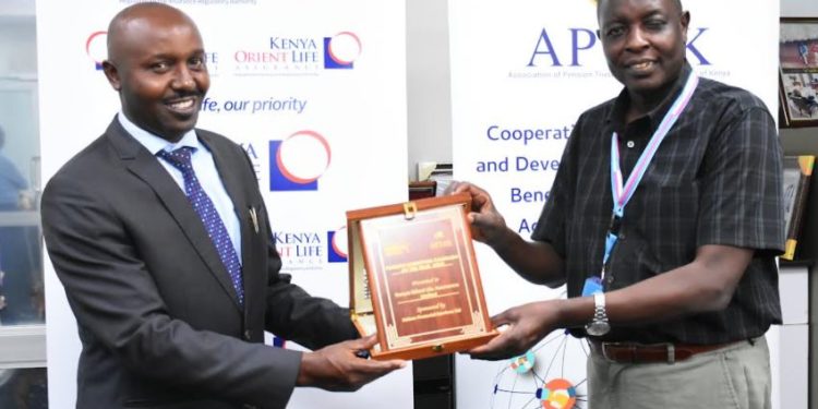 Kenya Orient Life Assurance General Manager Jackson Muli (L) receives the 'Pension Marketing Campaign of the Year' award from APTAK President Hosea Kili