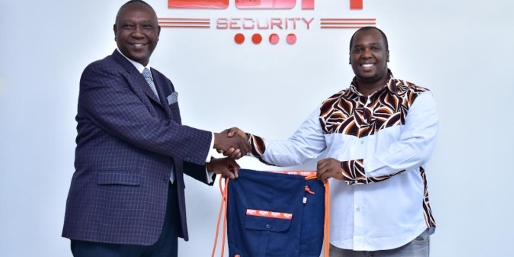 SGA Kenya Country Manager Lucas Ndolo (L) receives bags from Africa Collect Textiles General Manager Alex Musembi. The bags are made from old SGA guards uniforms in a bid to promote a clean environment