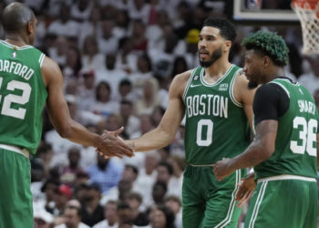 Boston Celtics forward Jayson Tatum (0) and center Al Horford (42) congratulate each other during a break in the second half of Game 4 during the NBA basketball playoffs Eastern Conference finals against the Miami Heat, Tuesday, May 23, 2023, in Miami. (AP Photo/Wilfredo Lee)