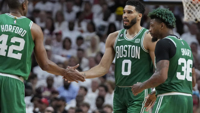 Boston Celtics forward Jayson Tatum (0) and center Al Horford (42) congratulate each other during a break in the second half of Game 4 during the NBA basketball playoffs Eastern Conference finals against the Miami Heat, Tuesday, May 23, 2023, in Miami. (AP Photo/Wilfredo Lee)