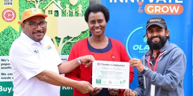 OLA Energy Kenya General Manager Dr. Yousef Elhemmali (L), Muthaiga Primary School Head teacher Lydia Ruguru and Chandaria Industries representative Chetankumar Patel hold a certificate of recycling issued to Muthai