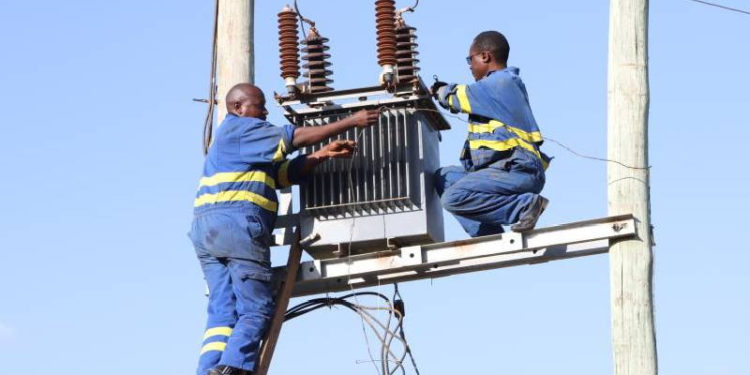 Kenya power technicians install a transformer at Ibutuka Village in Mbeere North in Embu County (Murithi Mugo, Standard)